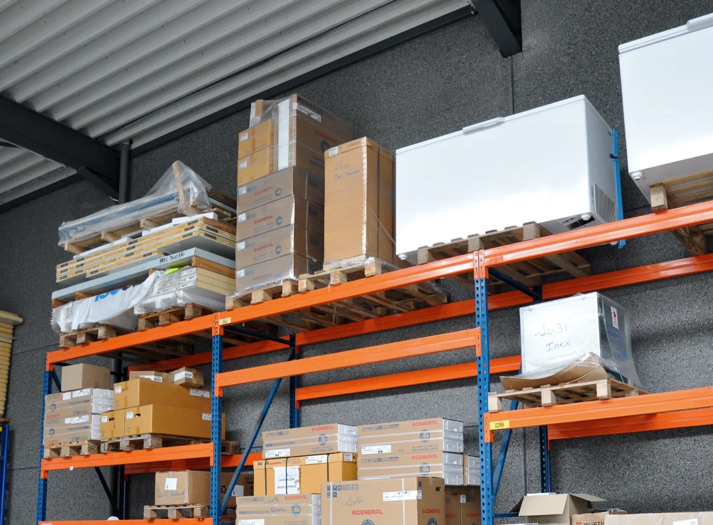 Palletrekken in het magazijn van AREC met gelabelde dozen en toestellen