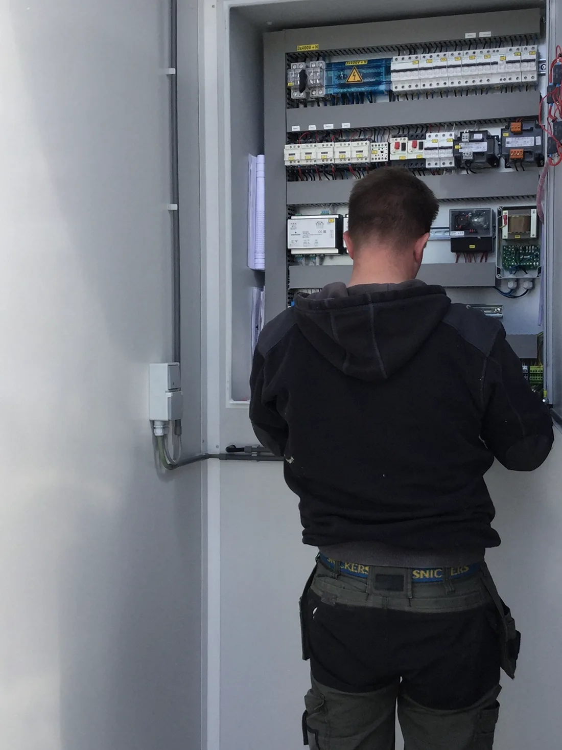 Technieker van Arec werkt in de schakelkast van een koelinstallatie